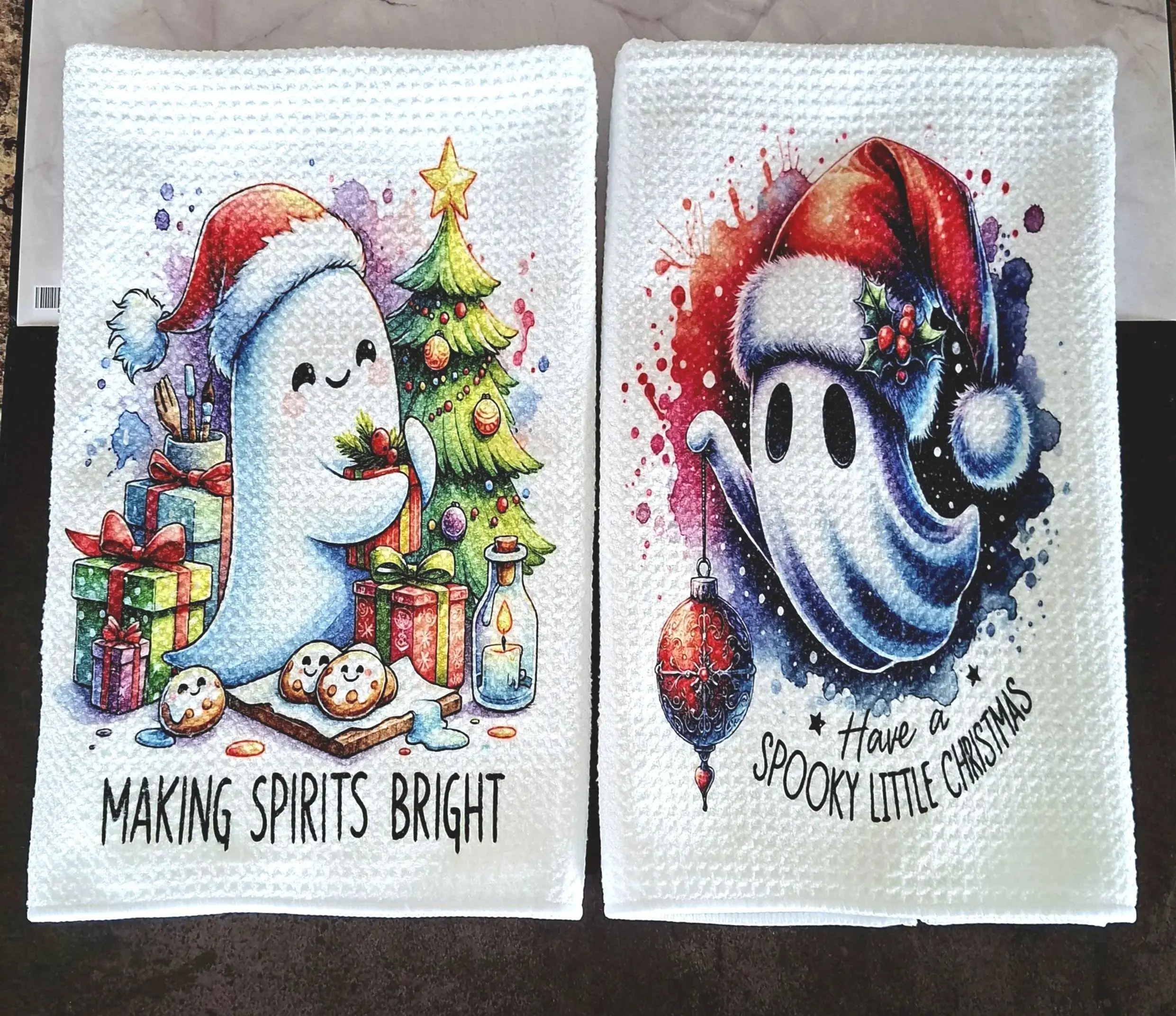 Spooky Christmas tea towel set featuring cute ghosts in Santa hats with tree and baubles, gothic festive kitchen décor.