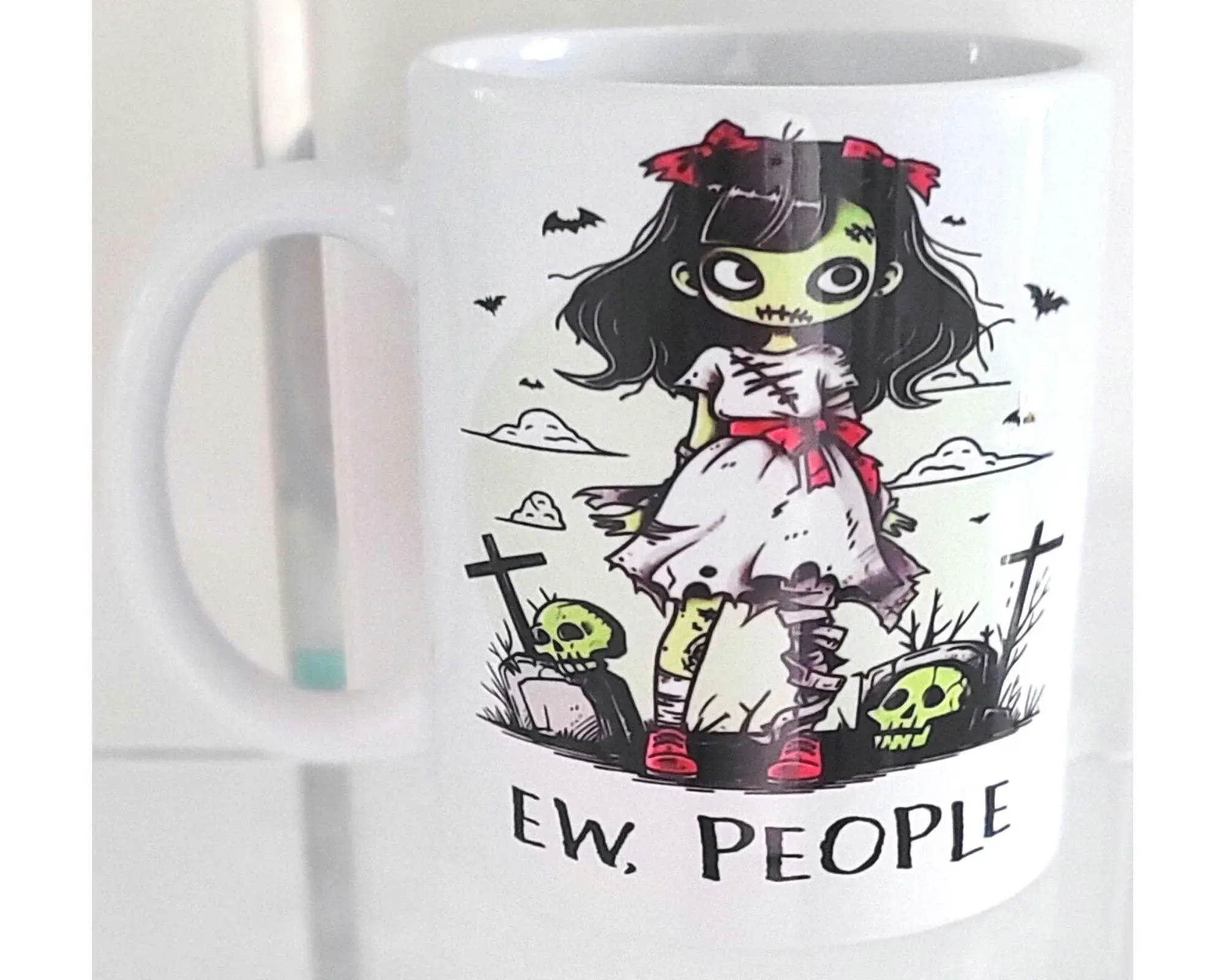 Funny gothic mug with cartoon zombie girl and “Ew, People” text – introvert coffee cup.