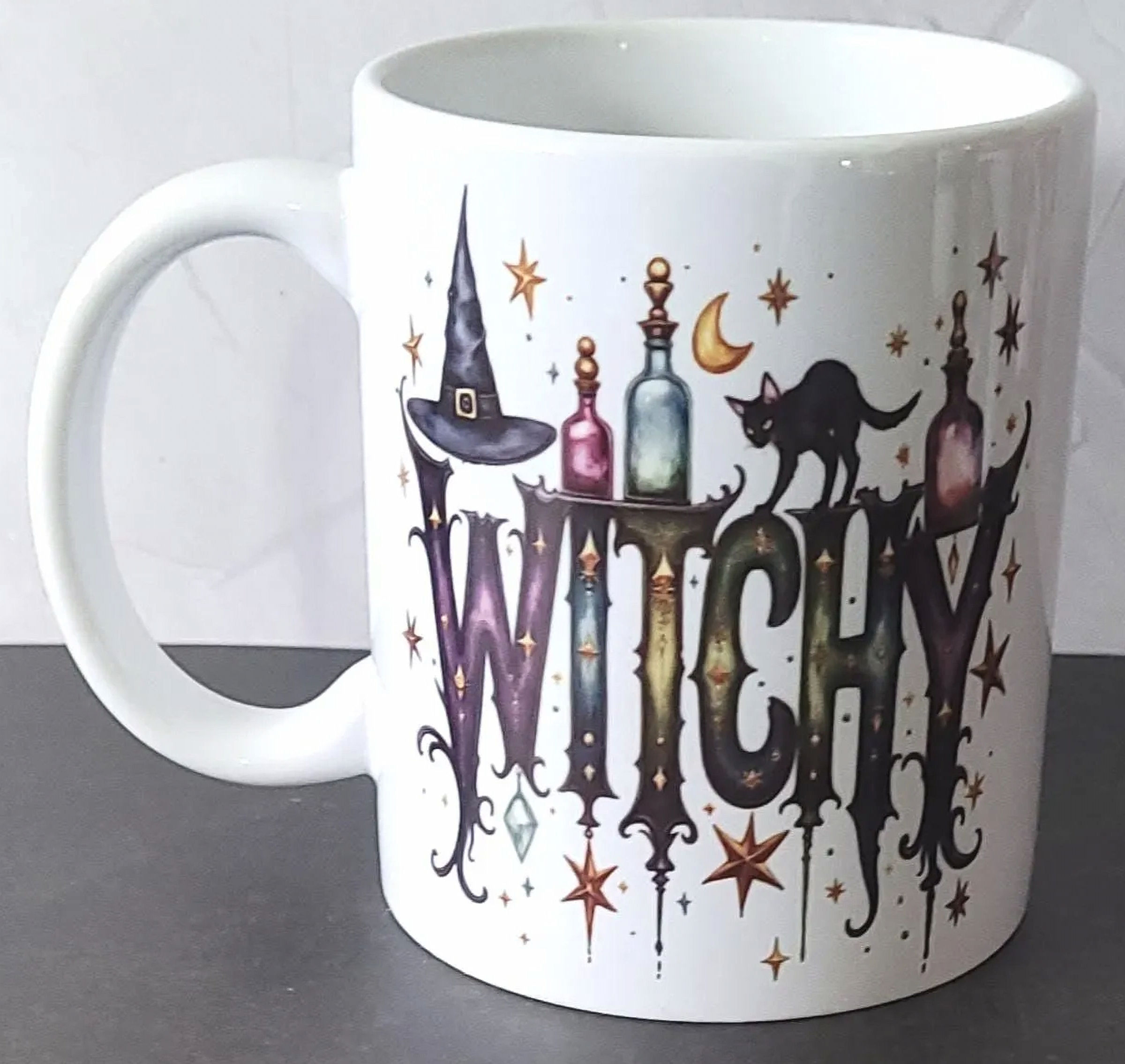 A gothic Witchy Mug featuring a cat, potions, and stars