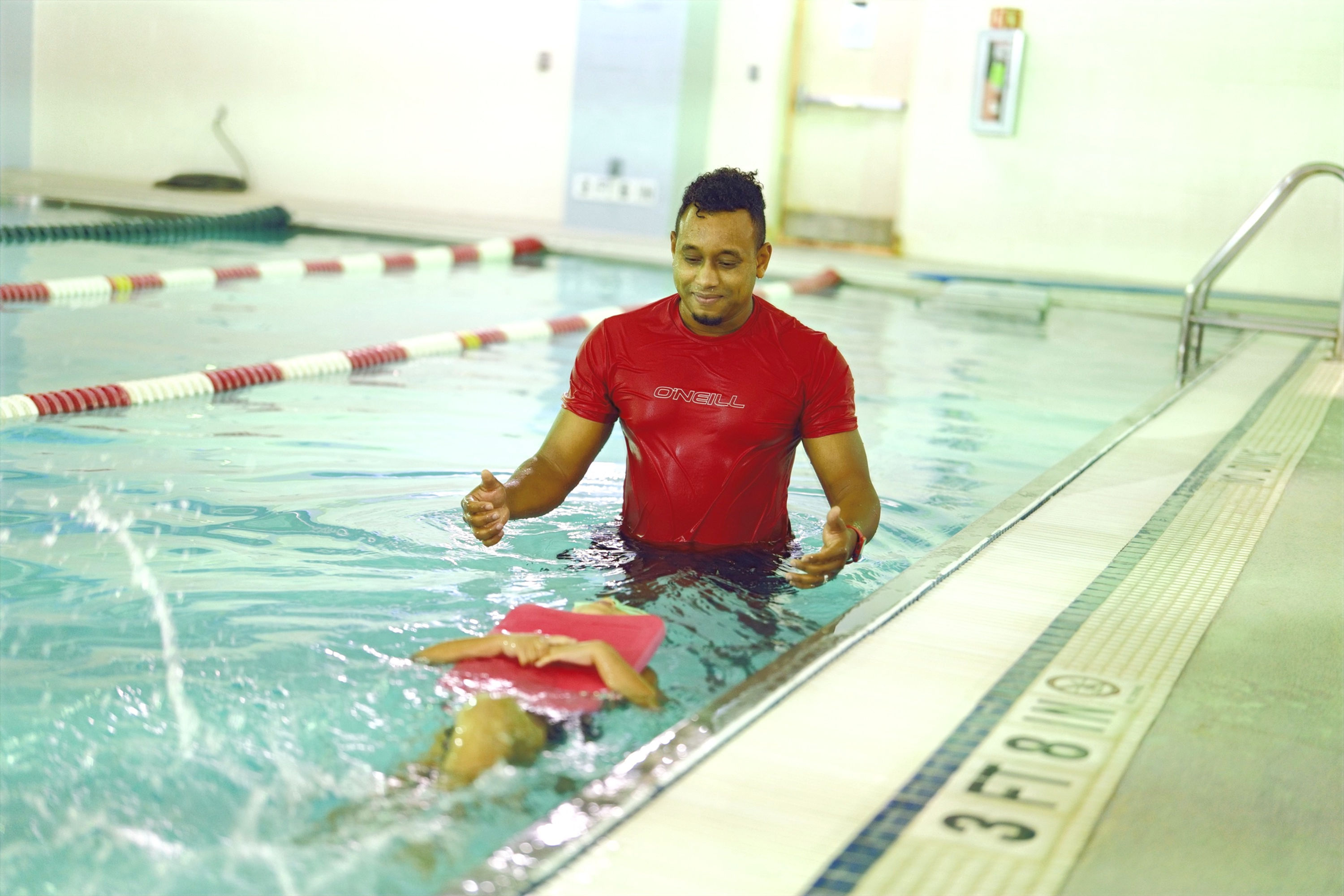 Swim Coach in the water teaching student a proper kick!