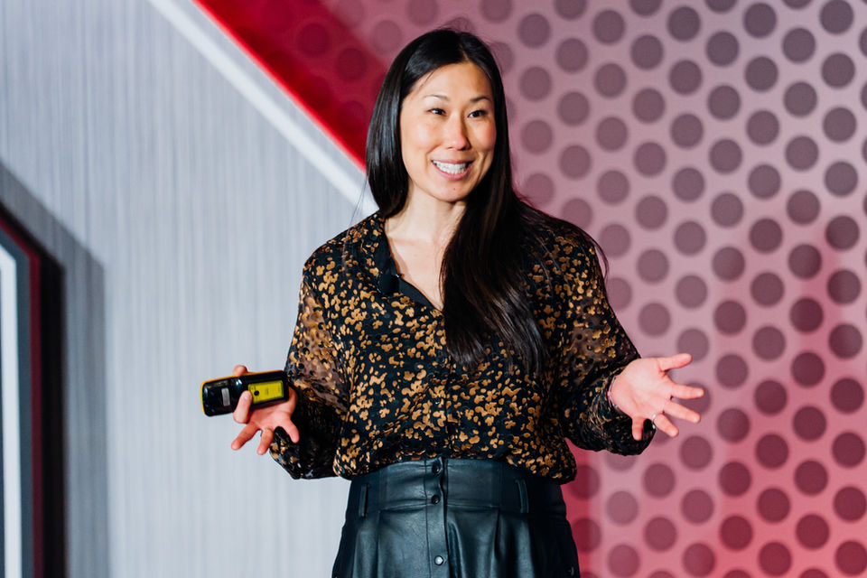 female keynote speaker presenting at corporate conference stage