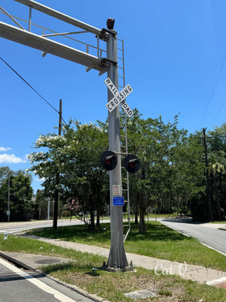 Railroad crossing sign beneath a bright blue sky, symbolizing crossroads, life choices, guidance, timing, and new directions.