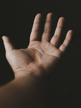 Open hand reaching upward against a dark background, symbolizing palmistry, hand analysis, self-discovery, ancient wisdom, and personal insight.