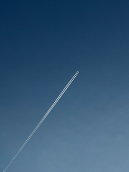 Moonlit sky with a bright contrail crossing the horizon, symbolizing the Ascendant and Midheaven in astrology, personal identity, life direction, and how we present ourselves to the world.