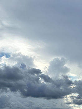 Dramatic storm clouds parting to reveal bright blue sky and sunlight, symbolizing hope, personal growth, resilience, and inner transformation.