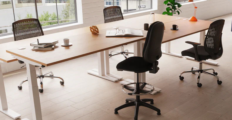 electric height adjustable desks in various positions shown in an office environment