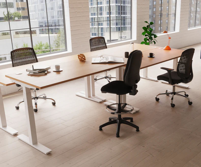 Electric height adjustable office desks shown in different positions in an office environment