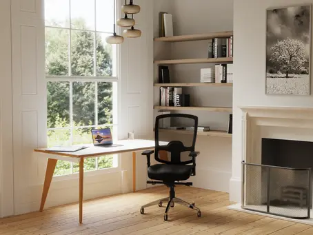 Ergonomic mesh office chair at a home office desk in a bright British living room with wooden floors and built-in bookshelves