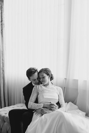 A groom holds his bride from behind