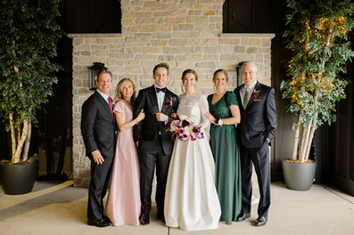 Newlyweds pose with their parents for a portrait