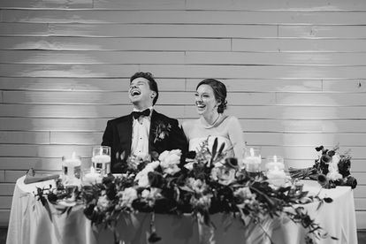 Newlyweds laughing during a wedding speech
