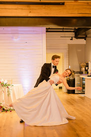 A bride gracefully holds out her hand during dance dip