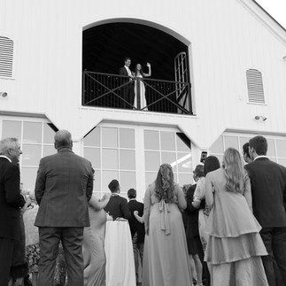 Bride and Groom Waving to Guests Off Balcony