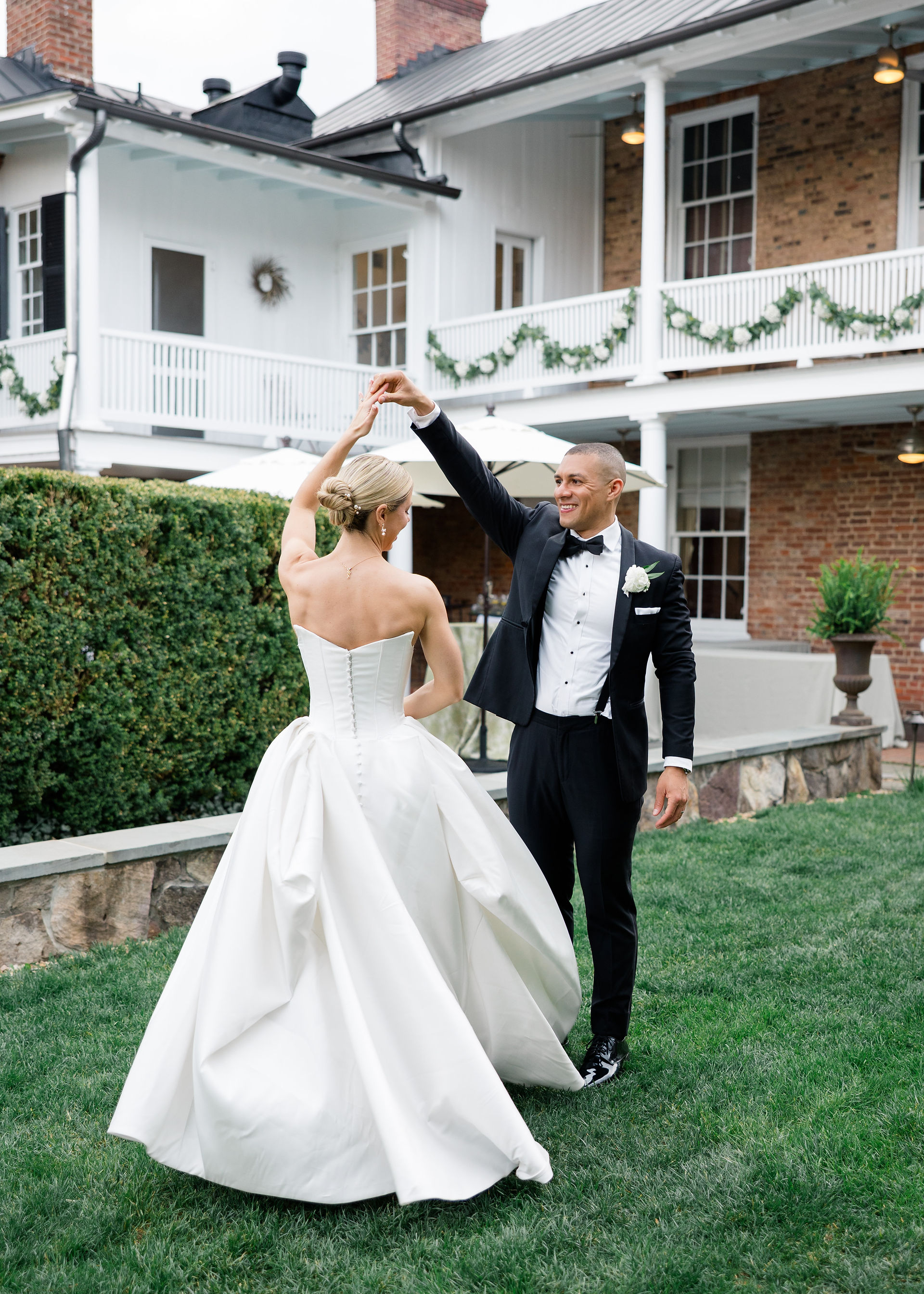 Groom twirling his bride in a garden