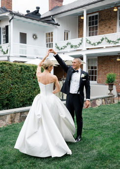 Groom twirling his bride in a garden