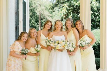 A bride and her bridesmaids smiling at the camera
