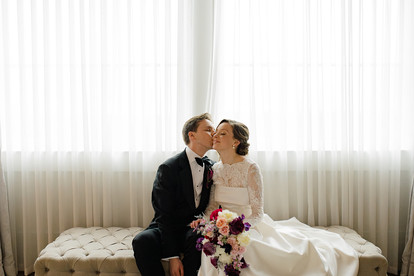 A groom kissing his bride on the cheek