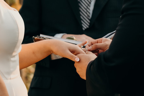 Groom placing ring on bride's finger