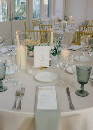 A wedding guest table with white and green linens