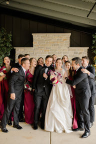 A wedding party hugging the newlyweds