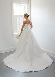 a bride looking down at her bridal bouquet in her wedding dress