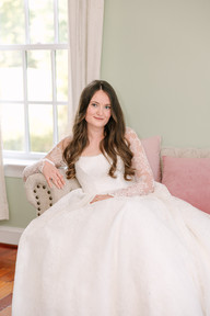A bride in her wedding gown sitting on a coach