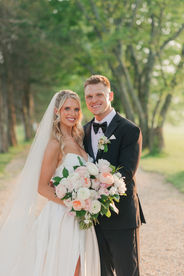 Newlyweds in a forest walkway smiling