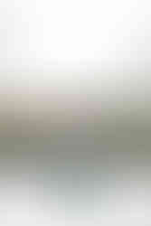 A groom and bride holding hands outside by the water