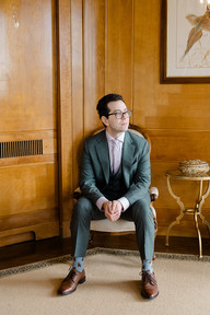 A groom sitting down in a chair in a house