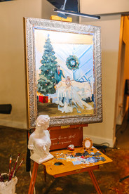 A live painting of a bride and groom next to a Christmas tree