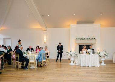 Wedding guests and couple bowing their heads to pray