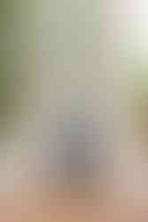 A groom posing in front of white columns