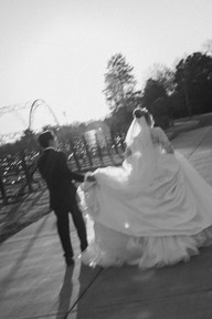 The groom helping his bride with the dress train