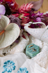 A box of rings surrounded by florals and shoes