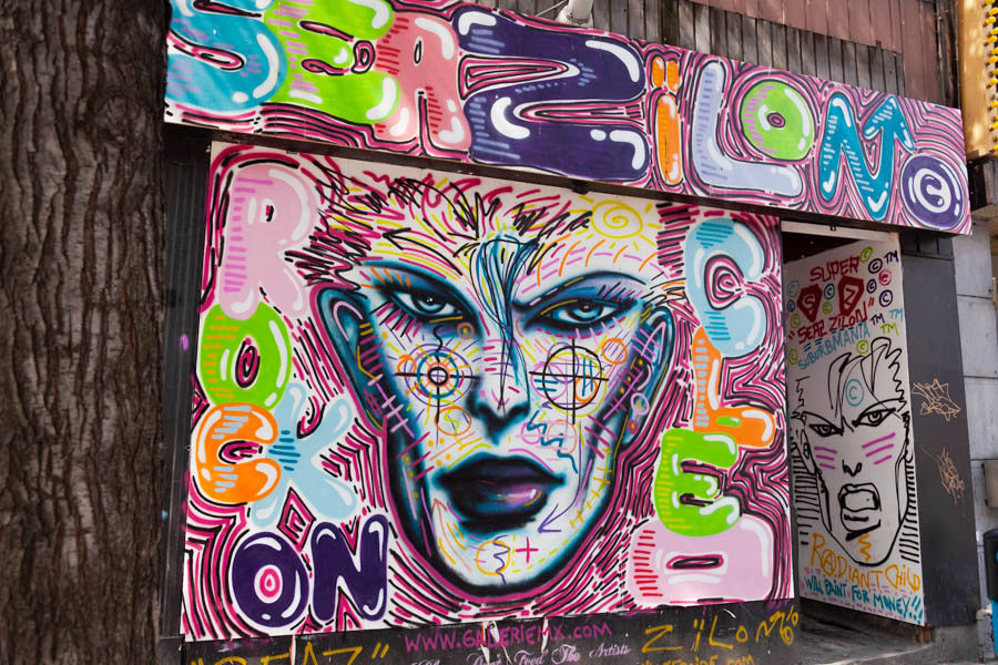 Zïlon, œuvre au néon, visage vert lumineux sur fond sombre, art urbain Montréal