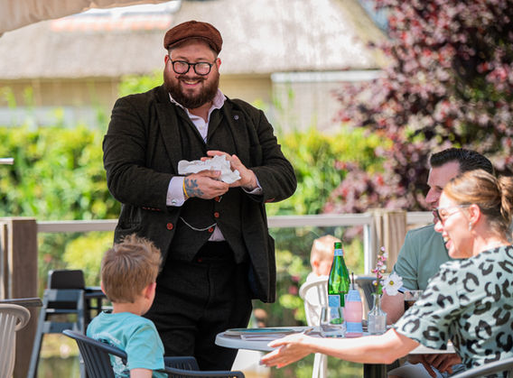 Goochelaar Tim Horsting goochelt met kaarten aan een tafel van een restaurant