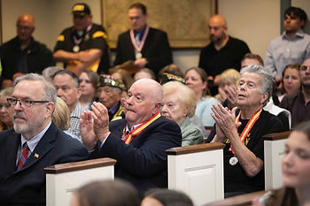 Among those applauding a medal recipient are fellow medal recipients Lawrence J. Ganley and James J. Long. Standing in the background are recipients Thomas R. Frodella, Sr. and son Thomas R. Frodella, Jr. The crowd was standing room only for the Morris County Commissioners Memorial Day Ceremony and presentation of Morris County Distinguished Military Service Medals. Photo courtesy of Morris County Commissioners.