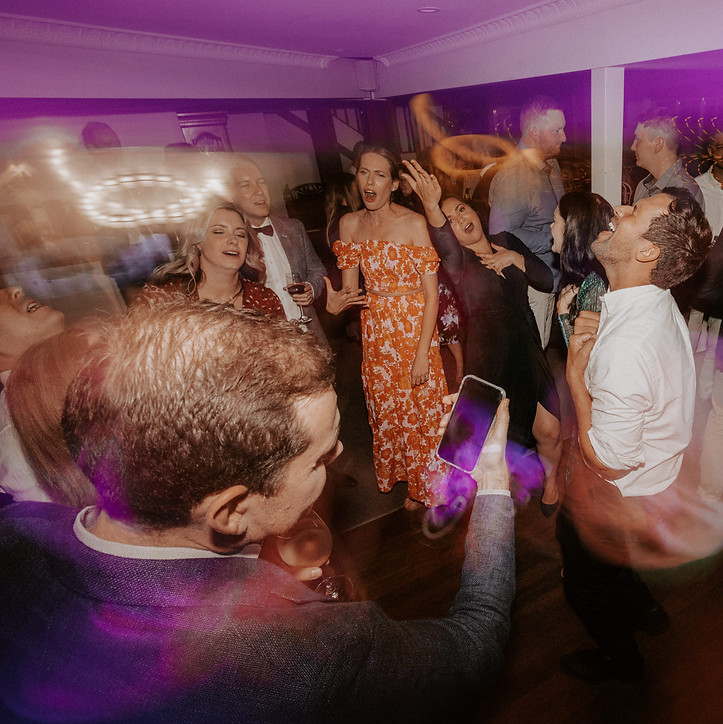 Guests dance and sing along to wedding DJ playing party tunes