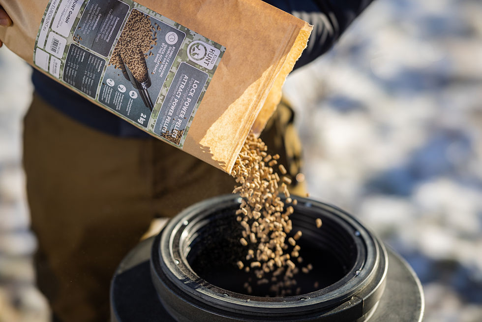 Detailaufnahme von herabfallenden Wildfutter-Pellets aus einer Papiertüte in einen Futtera