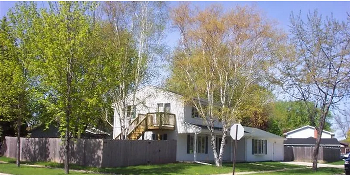 White two-story house with a fenced in backyard. Morning Glory Lane Home for ILS.