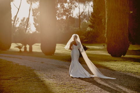 Sposa in un viale di cipressi al tramonto