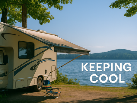 RV parked by lake with awning and chair in shade