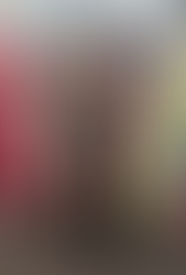 Teen wearing a black fitted prom dress with a beaded corset bodice and high slit, posing in a boutique with racks of prom gowns.