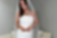 Bride wearing a strapless textured wedding gown and long veil while smiling during a bridal fitting appointment.