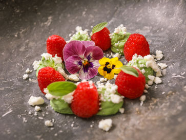 Creamy avocado mousse topped with fresh raspberries, served as an elegant appetizer.