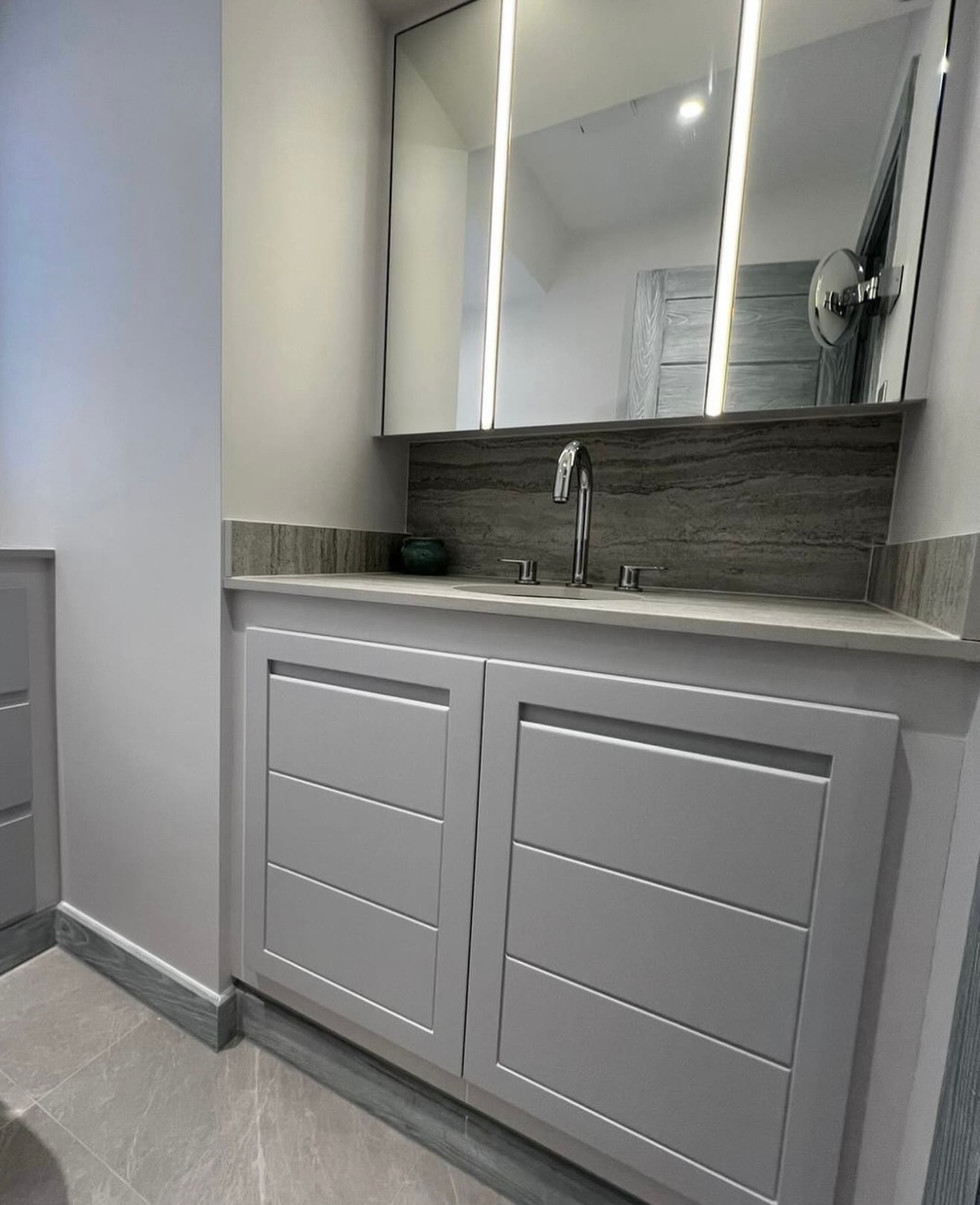 Modern gray bathroom vanity with illuminated mirror