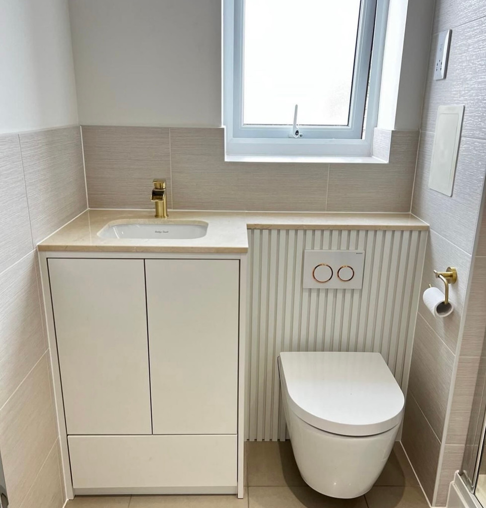 Modern bathroom with white vanity, toilet, and textured wall