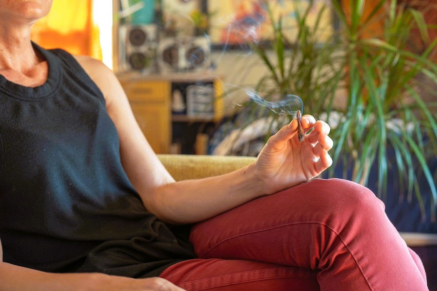 A person smoking weed while sitting on a couch