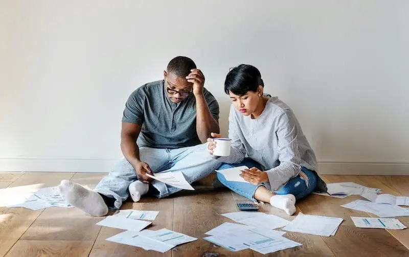 Cặp vợ chồng ngồi giữa giấy tờ tài chính, biểu hiện stress trong hôn nhân do áp lực tiền bạc và cuộc sống