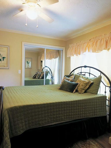 Bedroom with a bed, nightstand, and window with curtains and a door